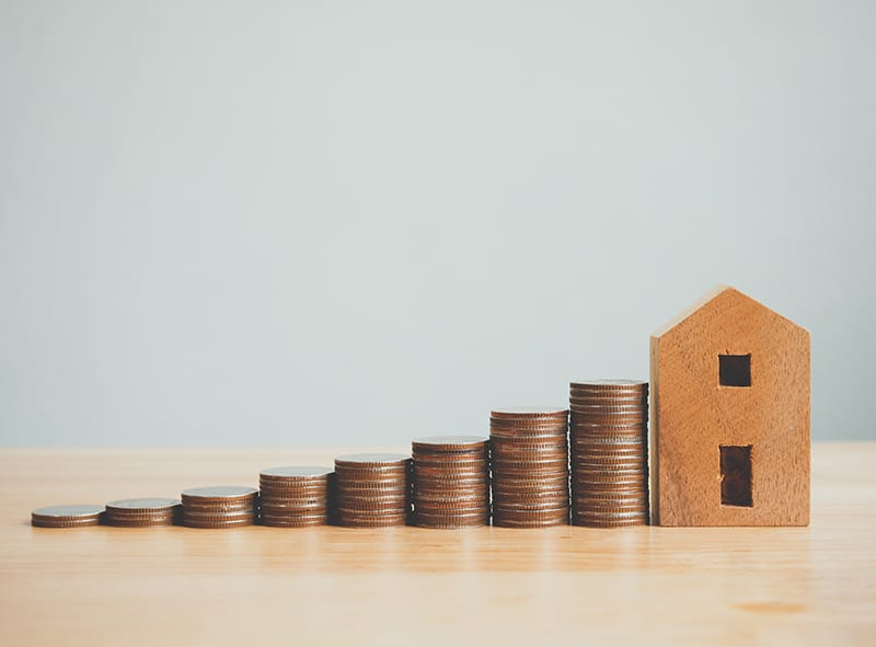 Money coin stack with wooden house