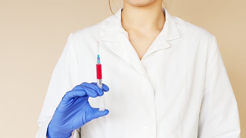 Nurse with gloves while holding a syringe