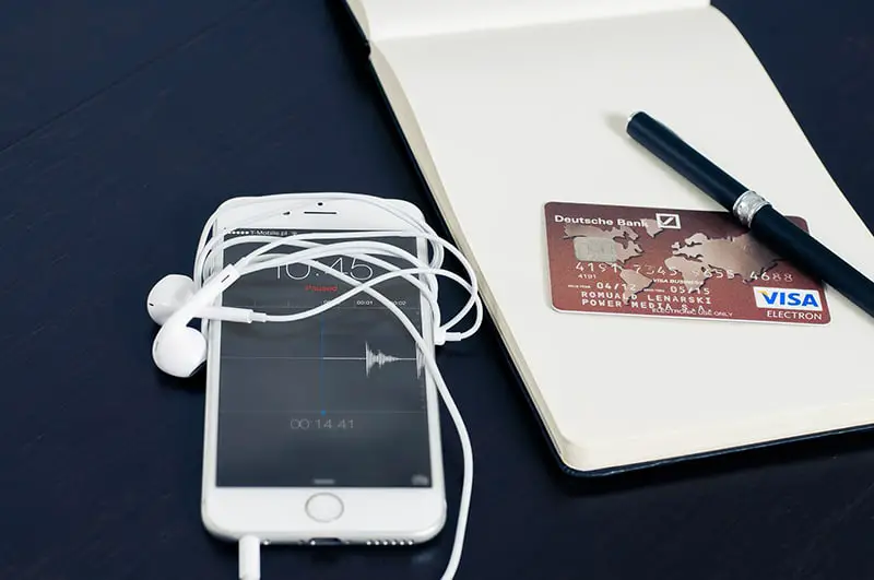 Mobile phone next to a credit card on a note pad