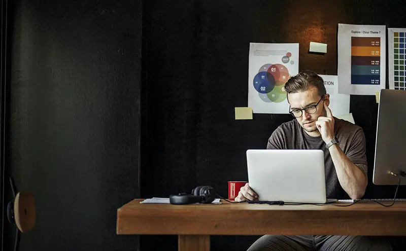 Startup business owners sitting at desk working on laptop