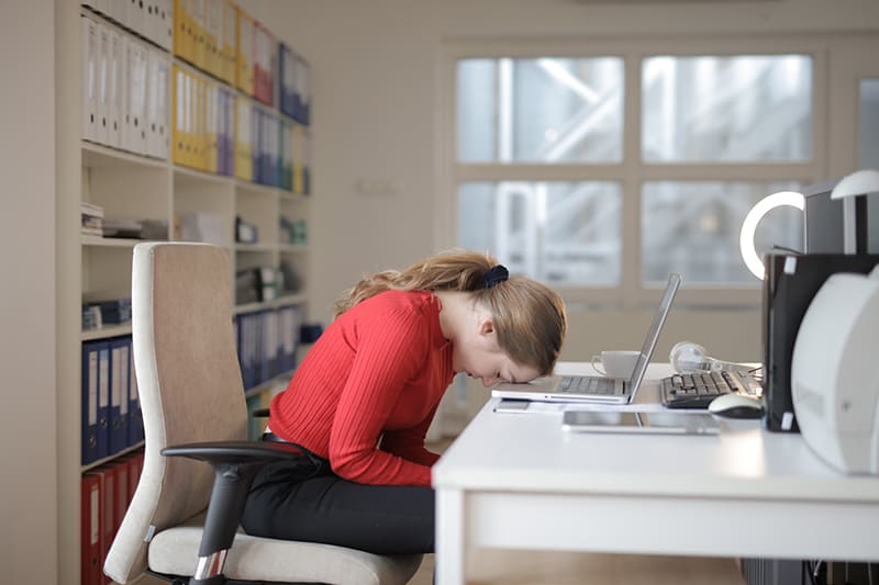 Woman in red shirt while leaning on the table