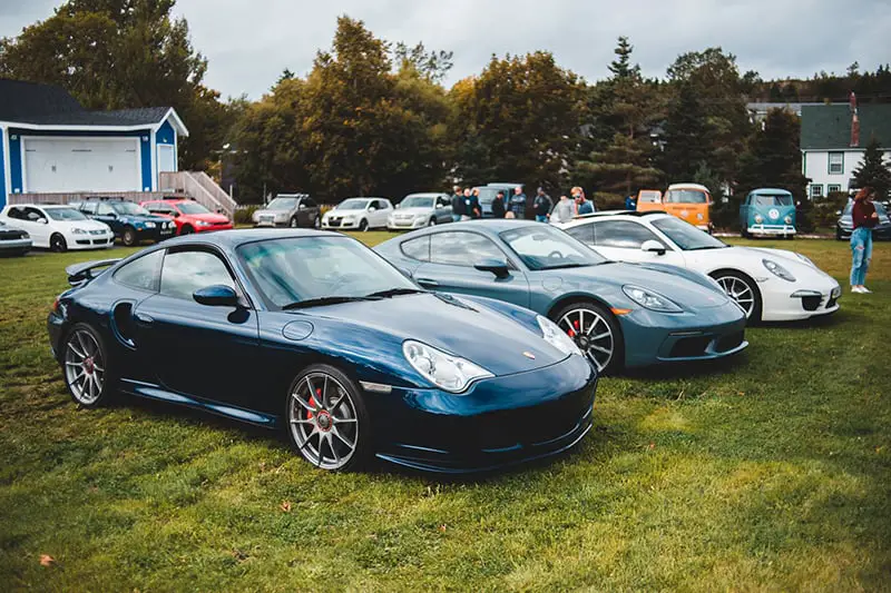 blue porsche 911 parked on green grass field