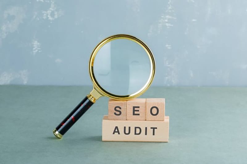 An image of SEO audit with a magnifying glass