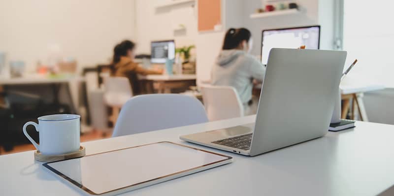 People working in office near the table with netbook and laptop