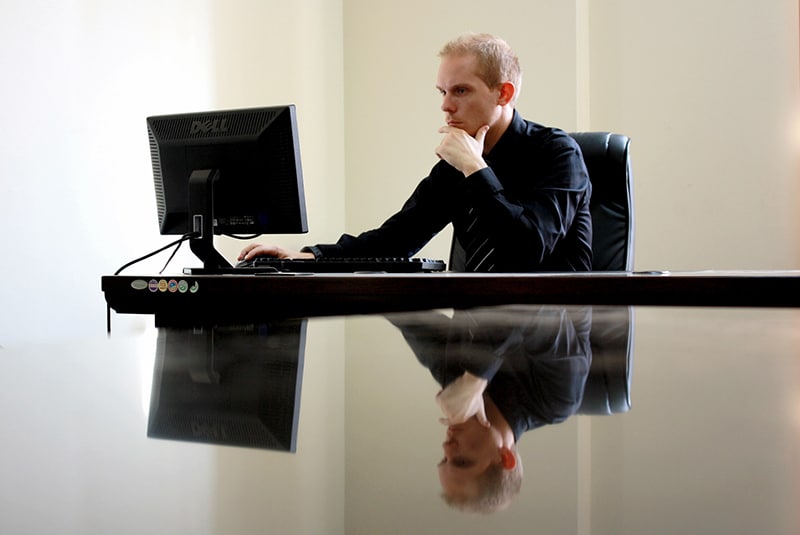 Man sitting facing PC inside the room