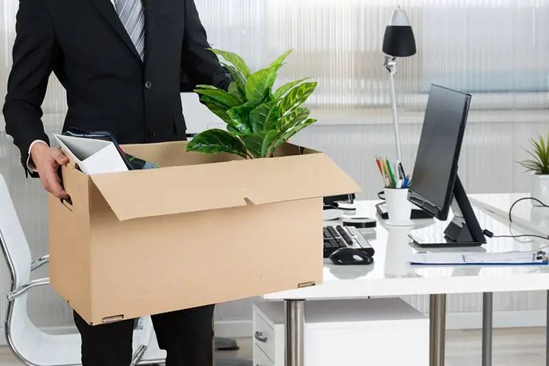 Person in black suit carrying cartoon box