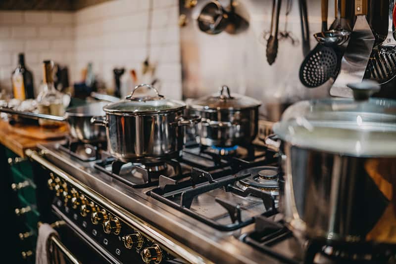 Kitchen equipment in restaurant – close-up shot of pots and pans on cooker
