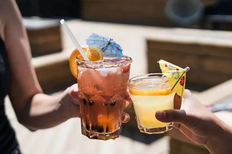 Two person holding drinking glasses