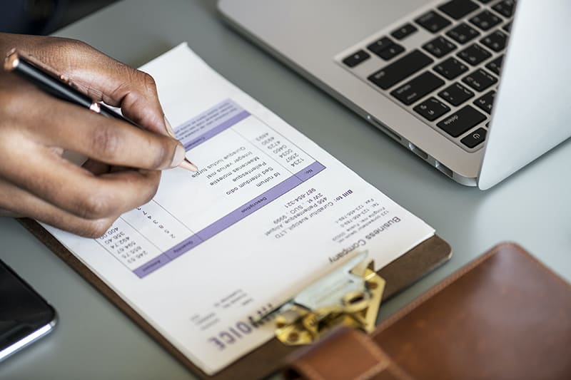 Closeup of business man checking tax invoice paper