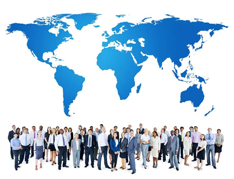 Group of employees under world map – representing global international business.