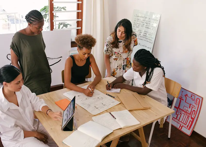 Employer and employees at working at a table in office