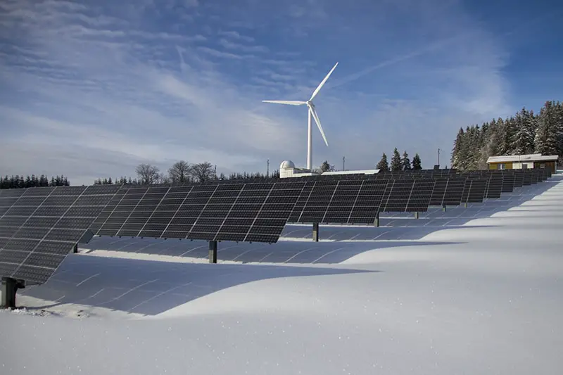 solar panels on snow with windmill