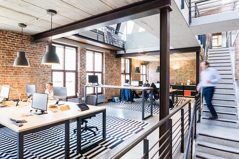 Man walking down the stairs in an open plan office