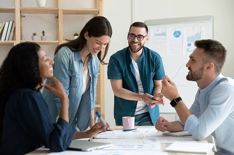 Smiling diverse colleagues gather in boardroom