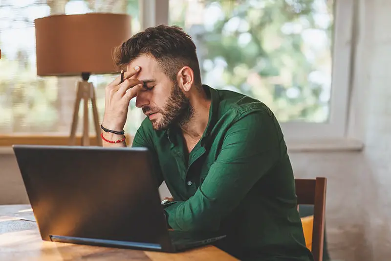 Young man having streesful time during working