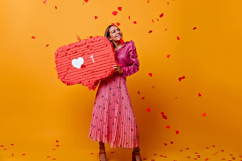 Full-length shot of blogger in fashionable clothes on orange background