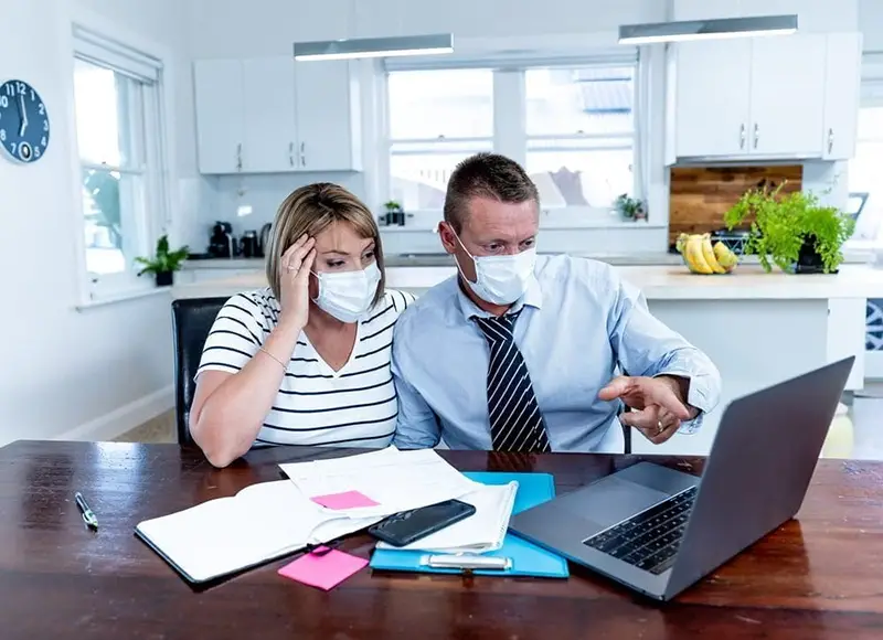 Couple sitting at a table completing a mortgage application online.