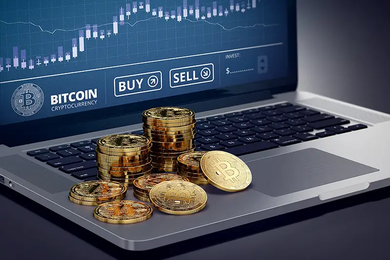 Bitcoins and laptop with chart illustration on the screen