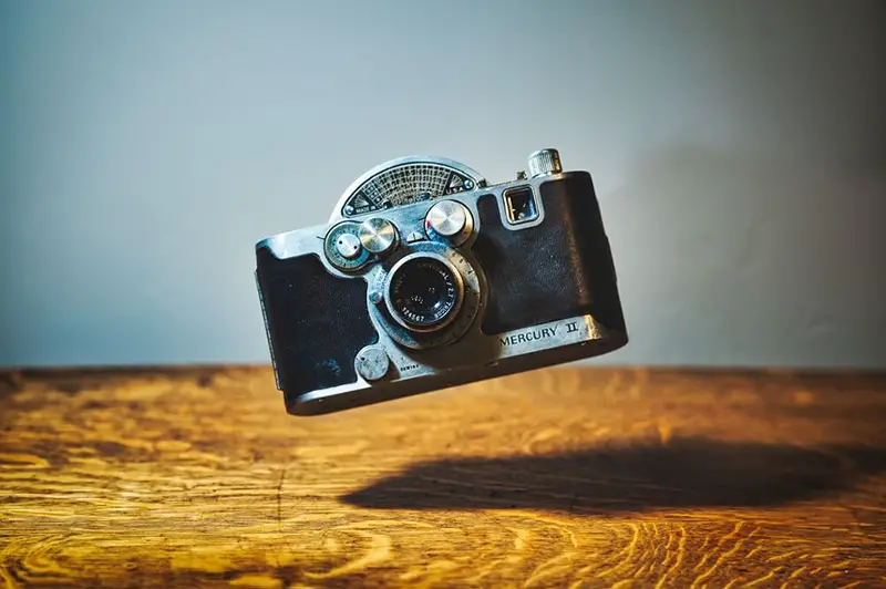 Black camera image floating on wooden desk