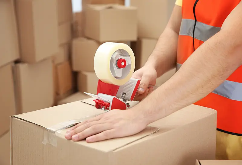 Close up man packing parcels