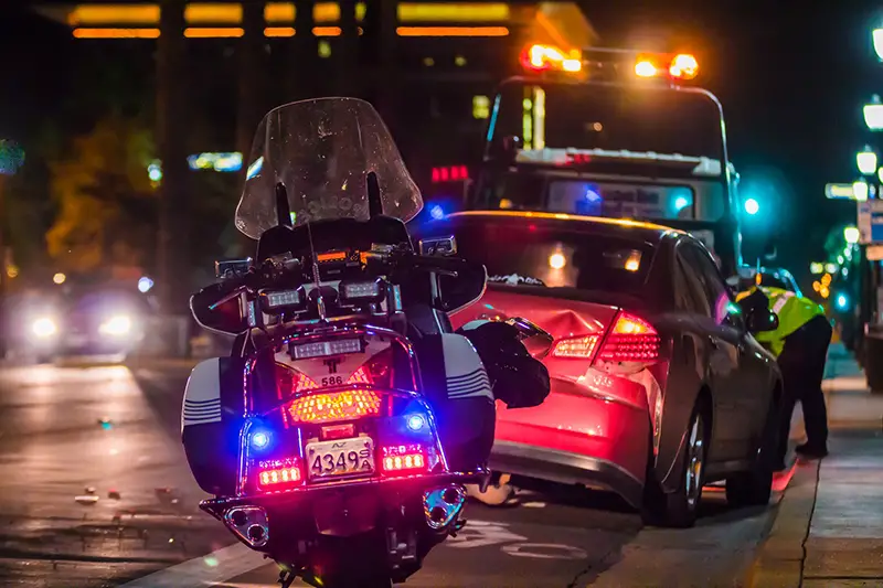 Car accident – policeman leaning over motor vehicle involved in an accident