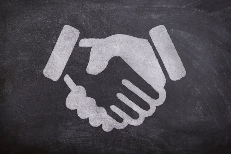 Drawing of handshake on a blackboard