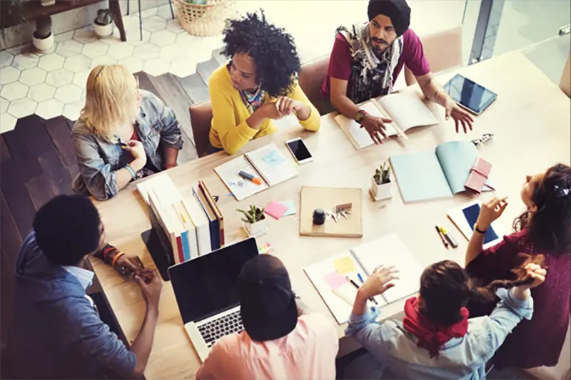 diverse group of employees sitting around a table working