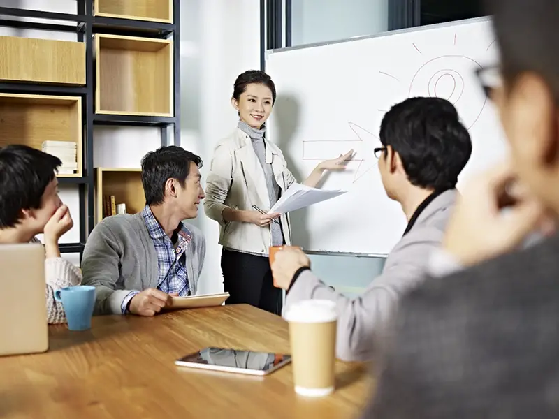 Woman standing in front near white board in the meeting