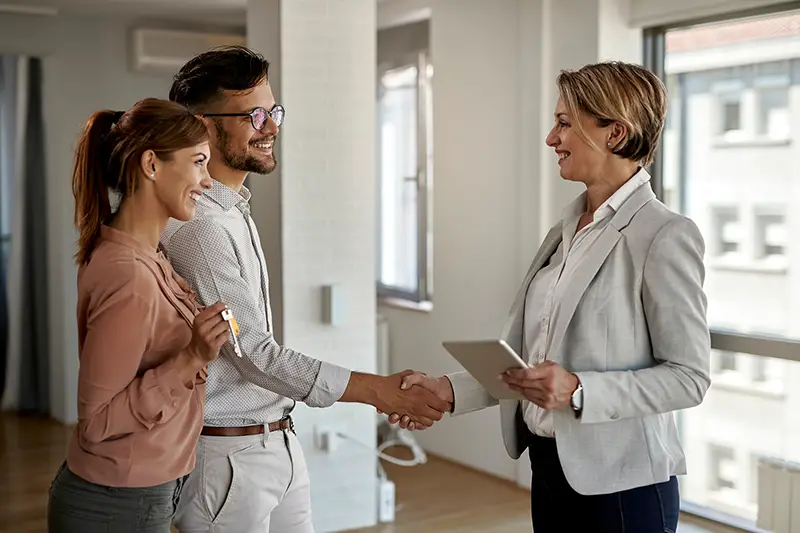 Happy real estate agent and a young couple