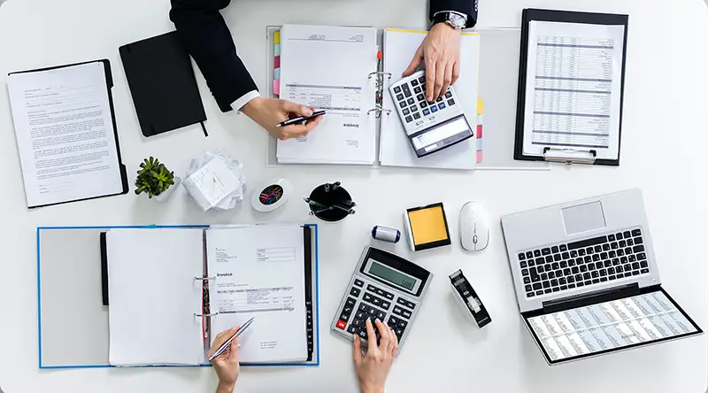 People working on the white table using calculator