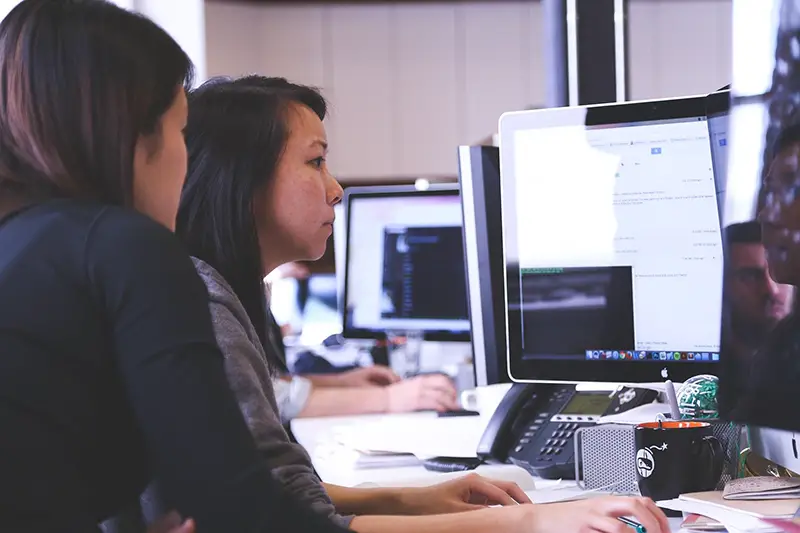 Two women working in front of computer