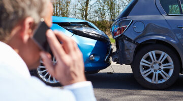 Man calling to his phone in front of car crashed