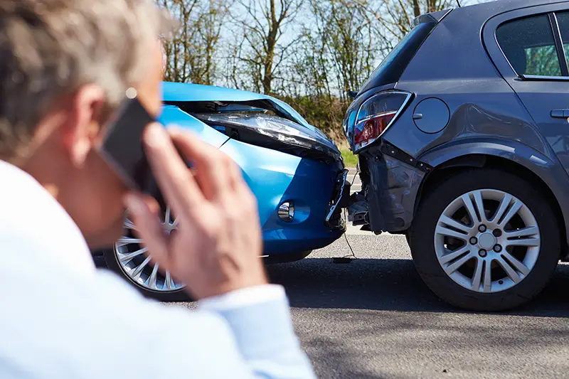 Man calling to his phone in front of car crashed