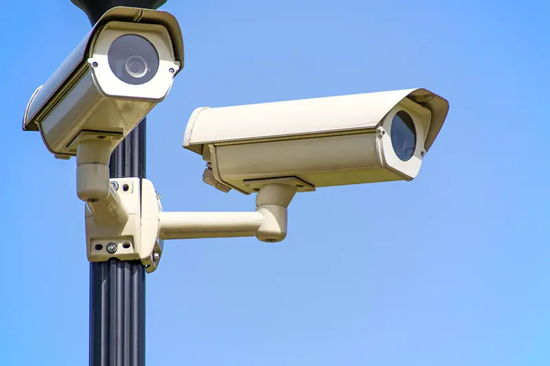 Two white Cctv camera mounted on black post