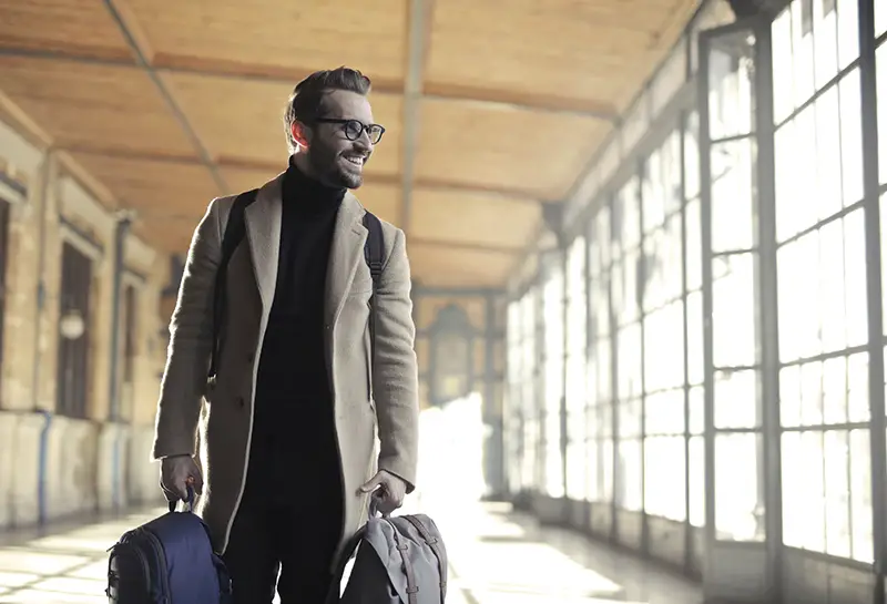 Man in brown robe carrying bag