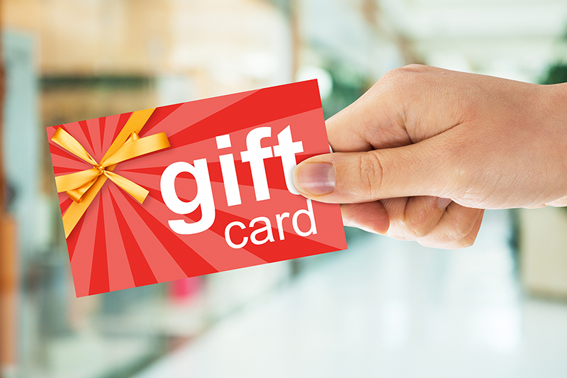 Cropped image of person's hand holding gift card