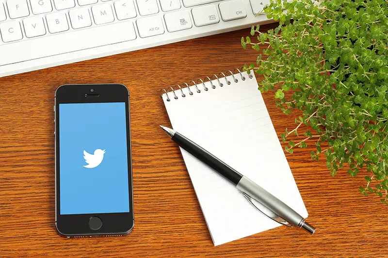 smartphone and notebook in a brown wooden table