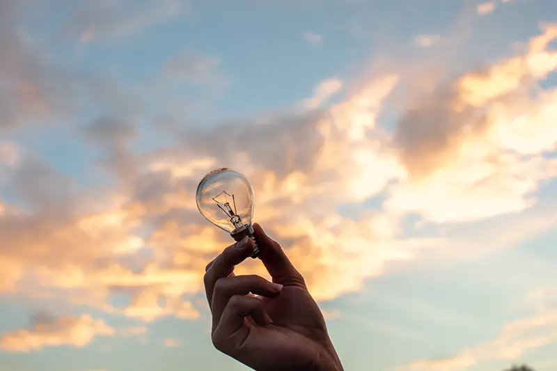 Person holding clear light bulb