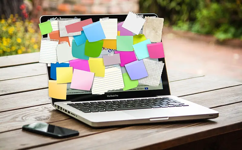 Laptop screen with sticky notes attached