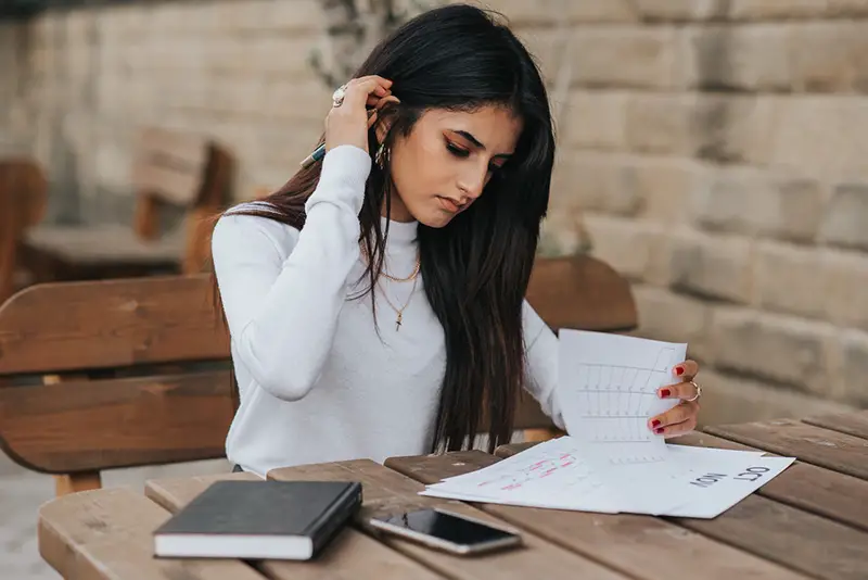 Ethnic young female entrepreneur reading notes
