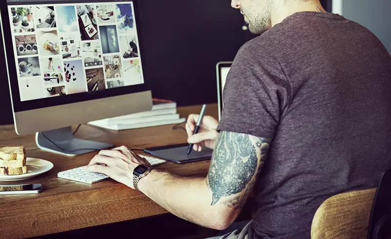 Man at desk working on a graphic design project on computer