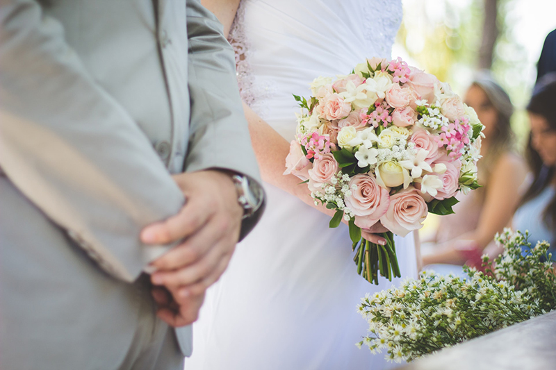 wedding couple standing in the aisle with the brode holding flowers