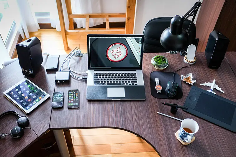 Laptop and gadgets on the top of dark brown wooden table