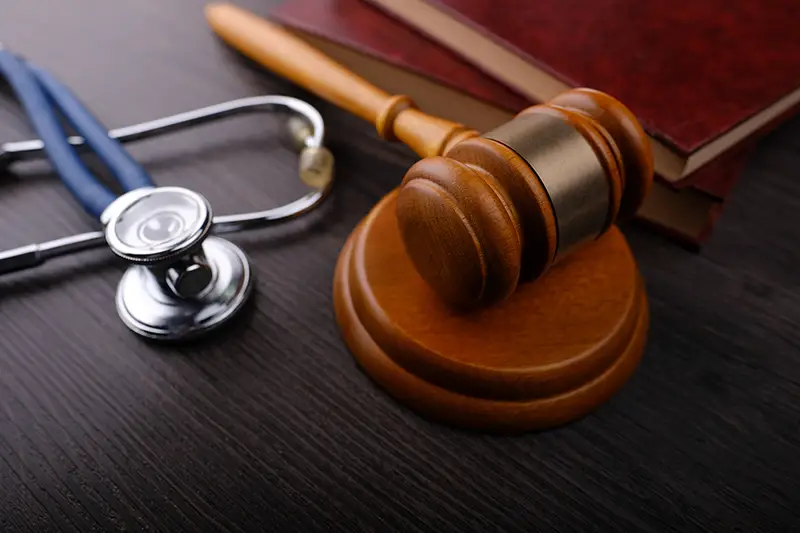 Gavel and stethoscope on wooden background