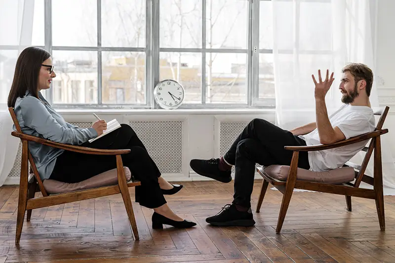 Man wearing white shirt talking to a woman