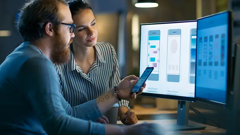 Man and woman apps designer working on front of computer