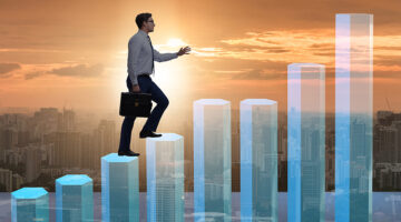 Businessman climbing bar charts in growth concept