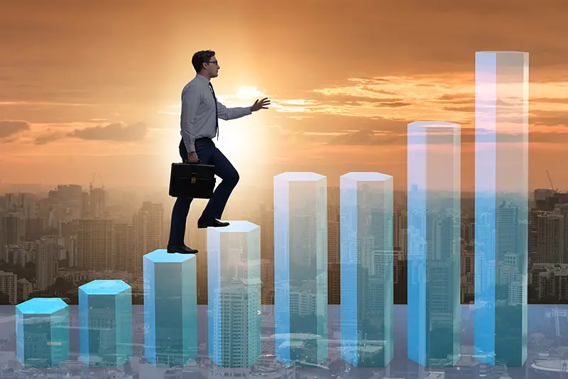 Businessman climbing bar charts in growth concept