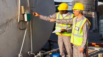 two industrial engineers inspection fuel tank in chemical plant