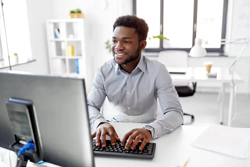 Man wering long sleeve working on his computer